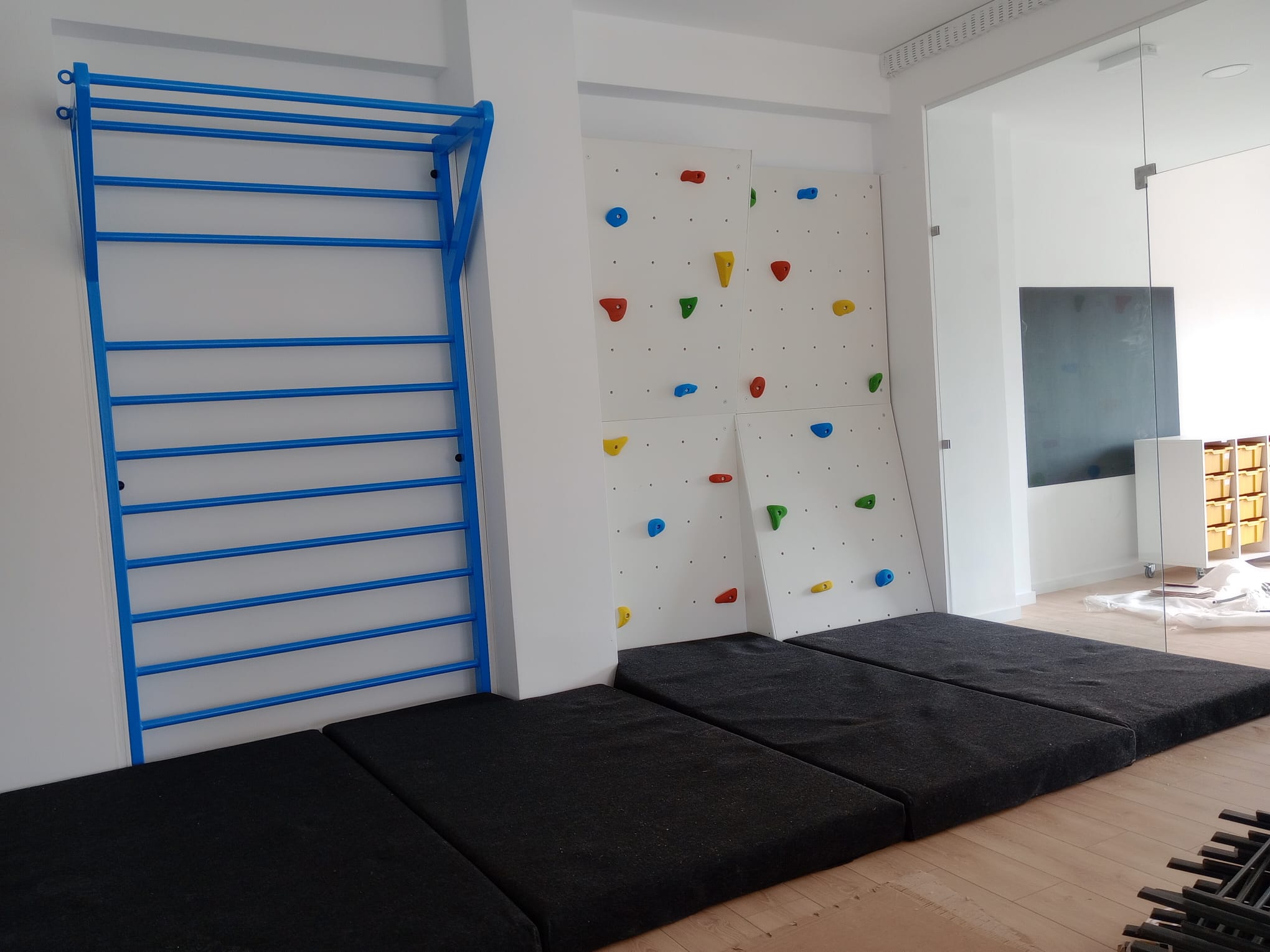 Painel de escalada Home Climbing instalado em casa, com colchões de segurança
